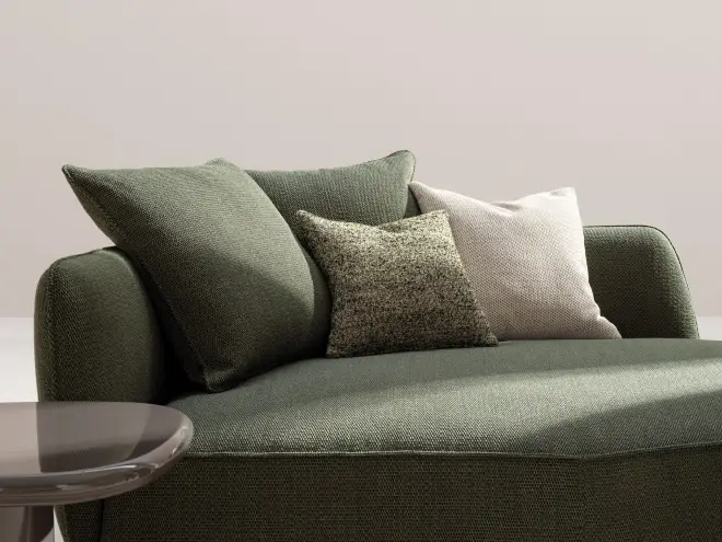 Divano Desir&eacute;e rivestito in tessuto verde con cuscini coordinati.